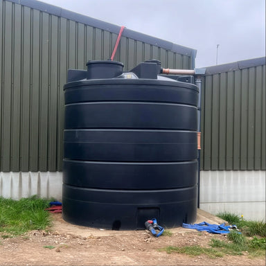 Side view of a 15,000 litre farm, Black MDPE, rainwater harvesting system with rooftop collection, installed on a concrete base, by Ecosure.